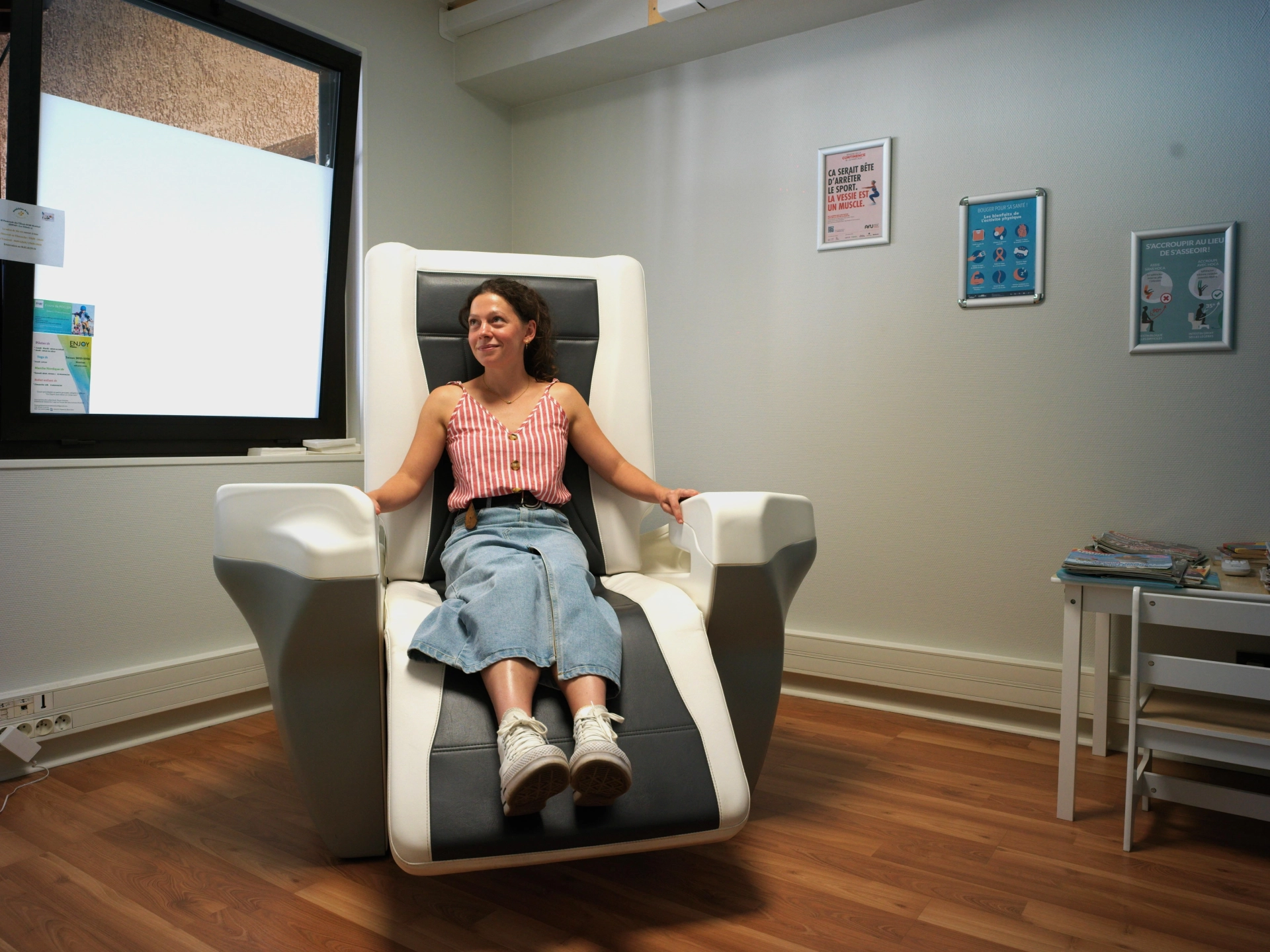Photo d'une femme assise sur le PelviCenter fauteuil de rééducation du périnée par stimulation électromagnétique, se trouvant au centre de santé du Marais de Montluel
